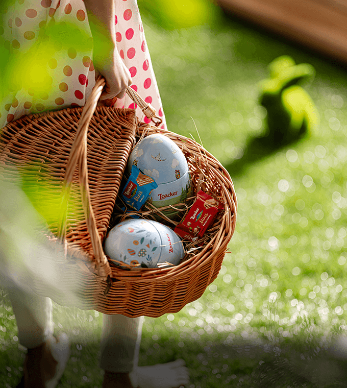 Girl carrying basket with Loacker Easter Egg, Premium Wafer & Chocolate Specialties, 4.95 oz. Collector's Tin and wafers inside