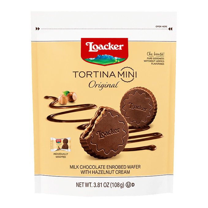Packaging of Loacker Tortina Mini Original, featuring chocolate-coated wafer discs with hazelnut cream. Background includes swirling chocolate and hazelnuts.