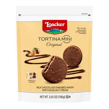 Packaging of Loacker Tortina Mini Original, featuring chocolate-coated wafer discs with hazelnut cream. Background includes swirling chocolate and hazelnuts.