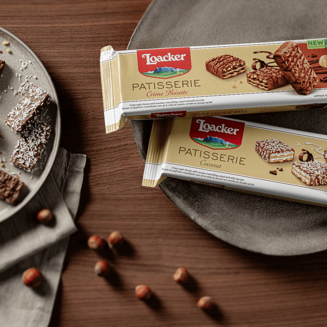 Loacker Patisserie Crème Noisette, Chocolate Coated Specialty, 3.53 oz. on a wooden table with cookies on a plate.