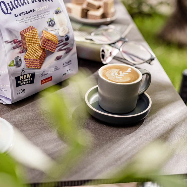 Quadratini Blueberry-Yogurt, Creme-Filled Wafers, 7.76 oz. Bag with coffee next to it