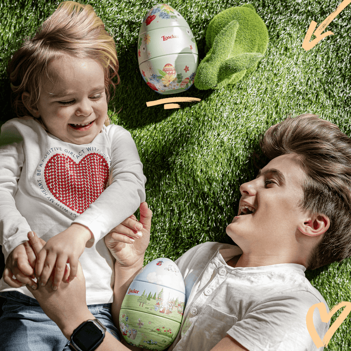 Loacker Easter Egg, Premium Wafer & Chocolate Specialties, 4.95 oz. Collector's Tin - Man and kid laughing on the field with Loacker Easter Eggs