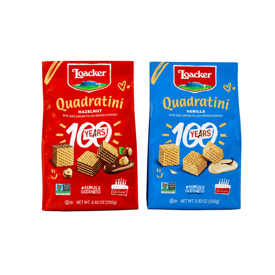 Two bags of Loacker Quadratini cookies side by side on a plain white background. The left bag is red and labeled Hazelnut, and the right bag is blue and labeled Vanilla.