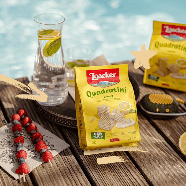 Quadratini Spring Value Pack with berries skewer, speaker, jar and glass of water with lemon slice and mint on the wooden table next to pool.