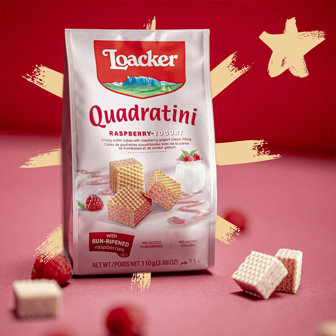 Quadratini Spring Value Pack Raspberry yogurt with raspberries and unwrapped wafers next to it.