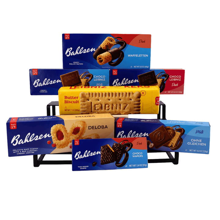 A group product display of assorted Bahlsen and Deloba chocolate and biscuit cookies on a black metal stand against a plain white background. Visible packaging includes blue Bahlsen boxes, a yellow Deloba biscuit box, and red boxes, with the products arranged in multiple sizes.
